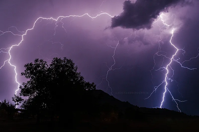 Extensive lightning strike surrounding the mountain and trees on both sides